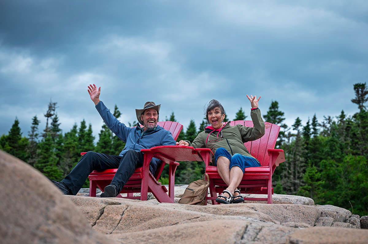 couple assis sur les chaines rouges de parc Canada
