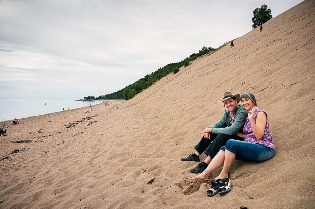 couple assis dans le sable des dunes de Tadoussac