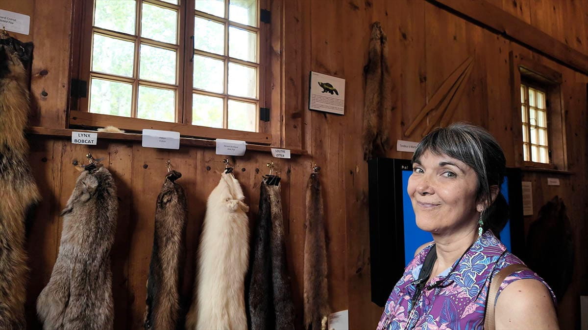 femme devant exposition de fourrure au musée Traite Chauvin tadoussac