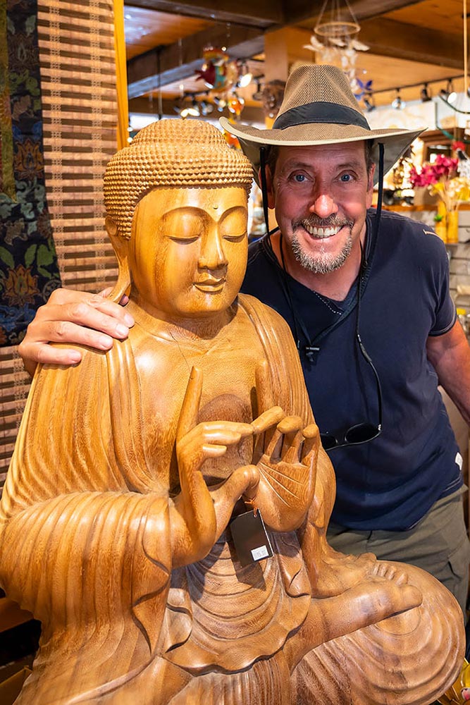 Homme à côté d'une sculpture, boutique Beau & Fou, Magog