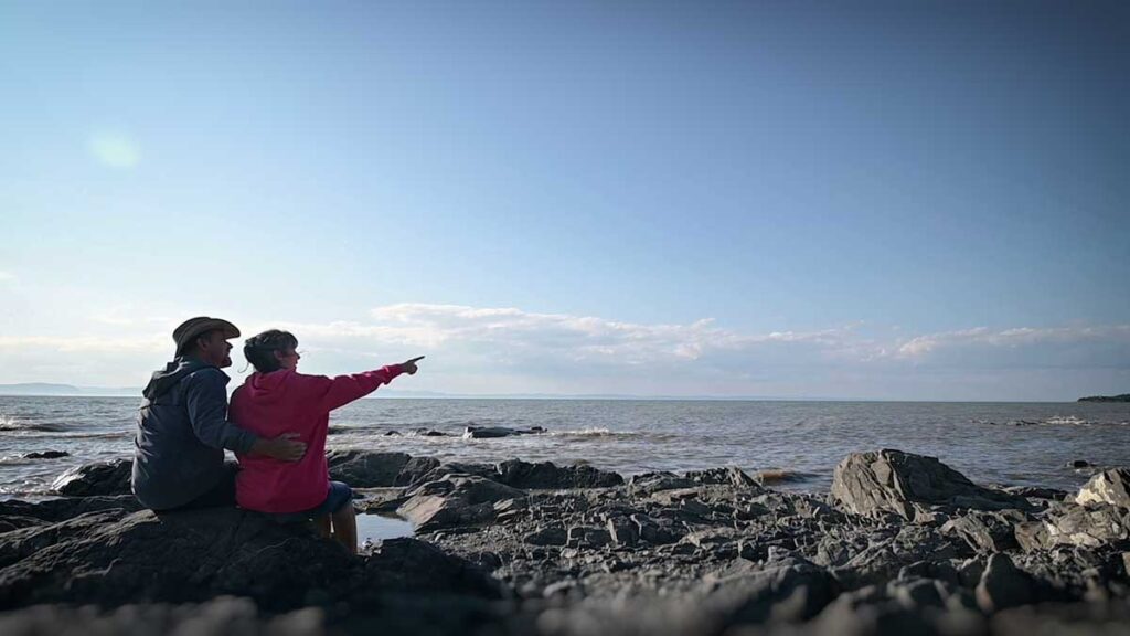 Anne et Eric assis sur rocher bord du fleuve